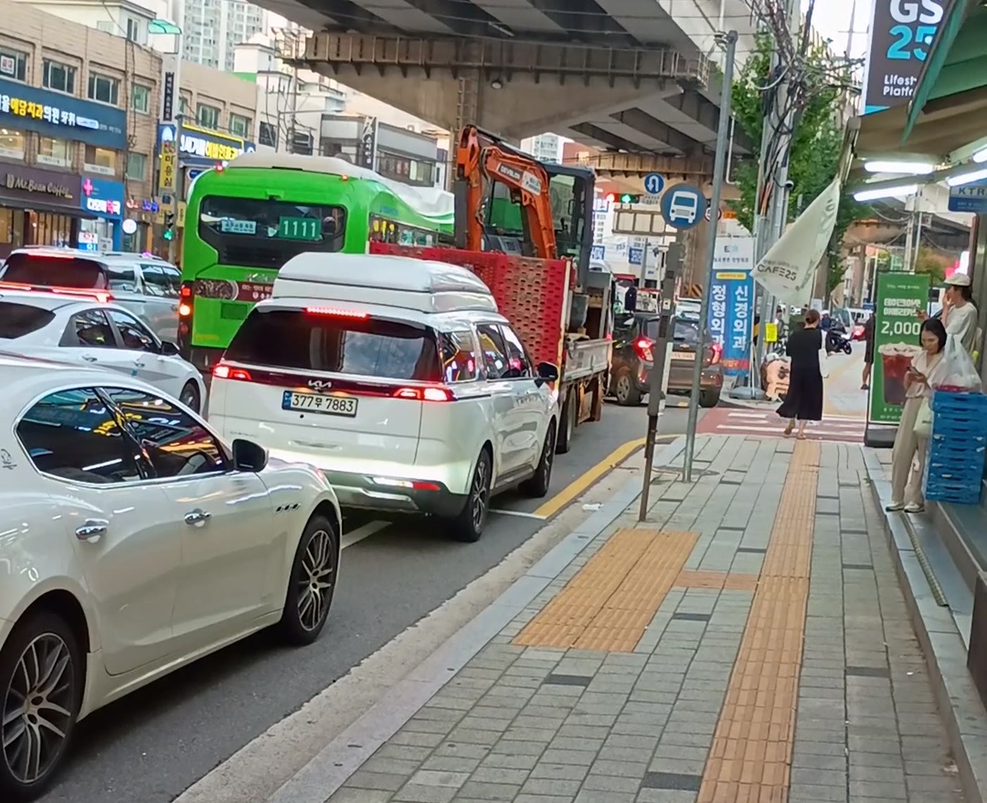 고가 하부 화랑로에서 승용차·굴착기 화물차·1111번 버스가 한 줄로 멈춰 선 정체 장면
